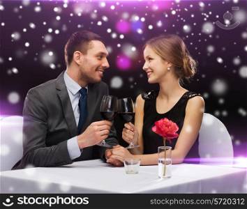 celebration, christmas, holidays and people concept - smiling couple clinking glasses of red wine at restaurant over night lights background