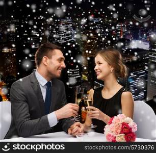 celebration, christmas, holidays and people concept - smiling couple clinking glasses of sparkling wine at restaurant over snowy night city background