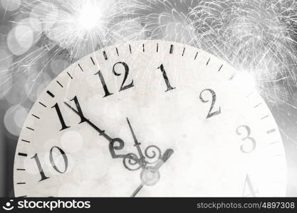 Celebration concept. Conceptual image of clock with bokeh lights and firework