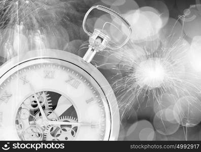 Celebration concept. Conceptual image of clock with bokeh lights and firework