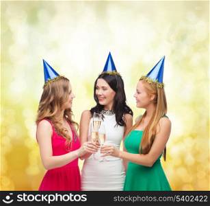 celebration, drinks, friends, bachelorette party, birthday concept - three smiling women wearing blue hats with champagne glasses