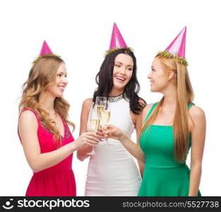 celebration, drinks, friends, bachelorette party, birthday concept - three smiling women wearing pink hats with champagne glasses