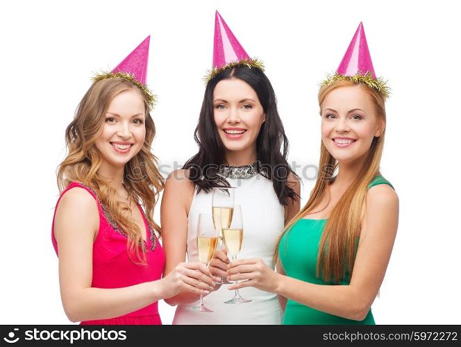 celebration, drinks, friends, bachelorette party, birthday concept - three smiling women wearing pink hats with champagne glasses
