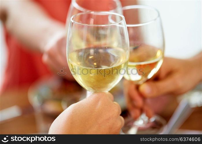 celebration, eating and holidays concept - close up of hands clinking wine glasses. close up of hands clinking wine glasses