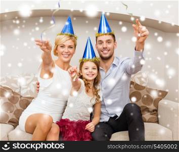 celebration, family, holidays and birthday concept - happy family in blue hats throwing serpentine