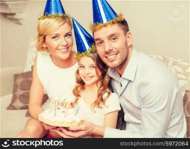 celebration, family, holidays and birthday concept - happy family in blue hats with cake
