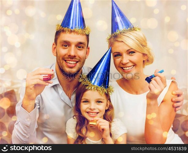 celebration, family, holidays and birthday concept - three smiling women wearing blue hats and blowing favor horns