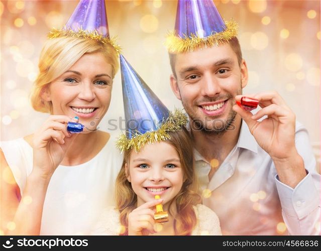 celebration, family, holidays and birthday concept - three smiling women wearing blue hats and blowing favor horns