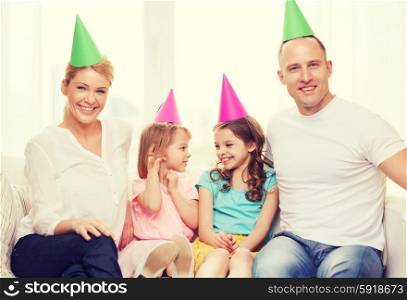 celebration, family, holidays, children and birthday concept - happy family with two chldren in hats celebrating