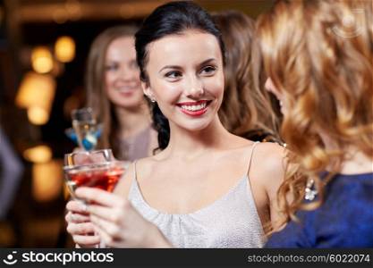 celebration, friends, bachelorette party and holidays concept - happy women drinking champagne and cocktails at night club