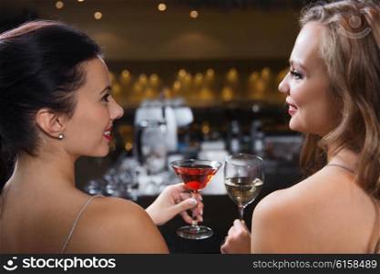 celebration, friends, bachelorette party and holidays concept - happy women drinking wine and cocktail at night club bar
