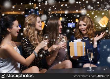 celebration, friends, bachelorette party, birthday and holidays concept - happy women with champagne glasses and gift box at night club