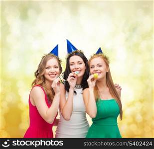celebration, friends, bachelorette party, birthday concept - three smiling women wearing blue hats and blowing favor horns
