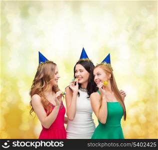 celebration, friends, bachelorette party, birthday concept - three smiling women wearing blue hats and blowing favor horns