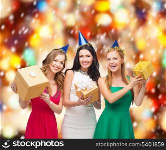 celebration, friends, bachelorette party, birthday concept - three smiling women wearing blue hats with gift boxes