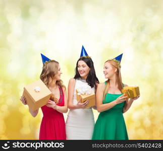 celebration, friends, bachelorette party, birthday concept - three smiling women wearing blue hats with gift boxes