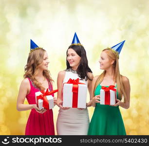 celebration, friends, bachelorette party, birthday concept - three smiling women wearing blue hats with gift boxes