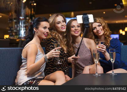 celebration, friends, bachelorette party, technology and holidays concept - happy women with champagne and smartphone selfie stick taking picture at night club