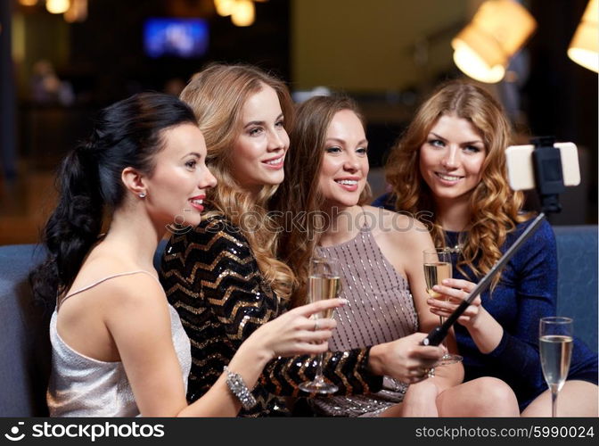 celebration, friends, bachelorette party, technology and holidays concept - happy women with champagne and smartphone selfie stick taking picture at night club