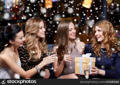 celebration, friends, new year, christmas and winter holidays concept - happy women with champagne glasses and gift box at bachelorette or birthday party at night club over snow