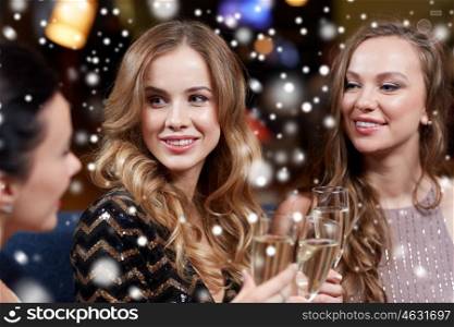 celebration, friends, new year, christmas and winter holidays concept - happy women with champagne glasses at bachelorette party at night club over snow