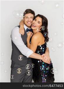 celebration, fun and holidays concept - happy couple hugging in soap bubbles at party. happy couple hugging in soap bubbles at party. happy couple hugging in soap bubbles at party