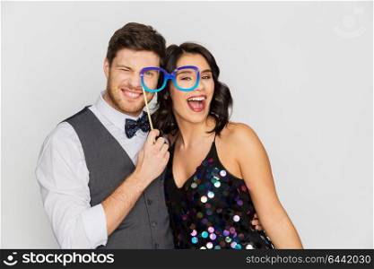 celebration, fun and holidays concept - happy couple posing with party glasses. happy couple with party glasses having fun