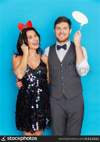 celebration, fun and holidays concept - happy couple posing with party props. happy couple with party props having fun