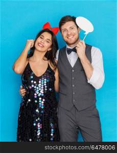 celebration, fun and holidays concept - happy couple posing with party props. happy couple with party props having fun. happy couple with party props having fun