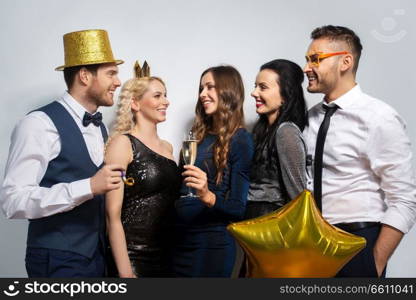 celebration, fun and holidays concept - happy friends posing with golden party props. happy friends with golden party props posing