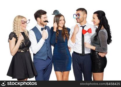 celebration, fun and holidays concept - happy friends posing with party props. happy friends with party props posing