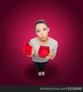 celebration, holidays and happiness concept - disappointed asian woman with empty red gift box