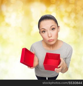 celebration, holidays and happiness concept - disappointed asian woman with empty red gift box