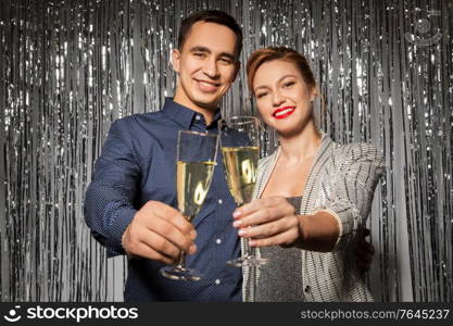 celebration, holidays and people concept - happy couple toasting champagne glasses at party. happy couple toasting champagne glasses at party