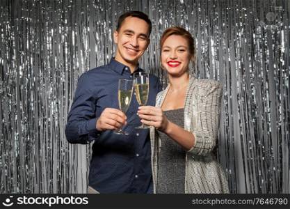 celebration, holidays and people concept - happy couple toasting champagne glasses at party. happy couple toasting champagne glasses at party