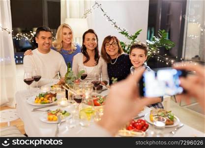 celebration, holidays and people concept - happy family having dinner party at home and photographing by smartphone. family photographing by smartphone at dinner party