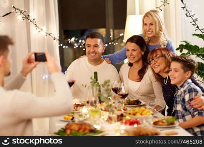 celebration, holidays and people concept - happy family having dinner party at home and taking selfie by smartphone. family having dinner party and taking selfie