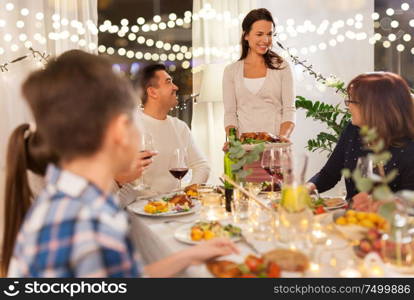 celebration, holidays and people concept - happy family having dinner party at home. happy family having dinner party at home