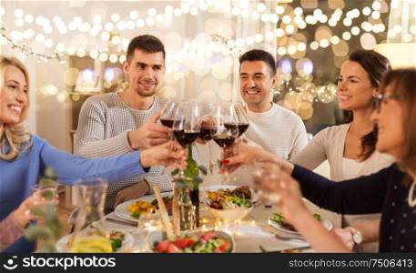 celebration, holidays and people concept - happy family having dinner party, drinking red wine and toasting at home. happy family having dinner party at home