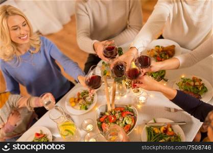 celebration, holidays and people concept - happy family having dinner party, drinking red wine and toasting at home. happy family having dinner party at home