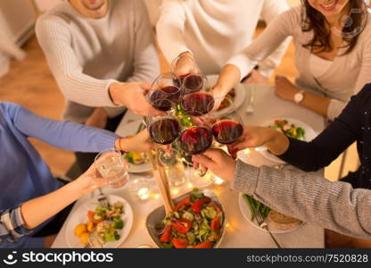 celebration, holidays and people concept - happy family having dinner party, drinking red wine and toasting at home. happy family having dinner party at home