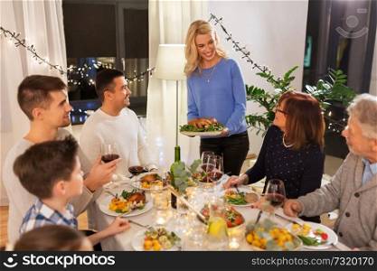 celebration, holidays and people concept - happy family having roast chicken for dinner party at home. happy family having dinner party at home