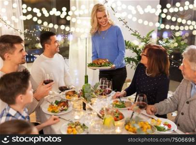 celebration, holidays and people concept - happy family having roast chicken for dinner party at home. happy family having dinner party at home