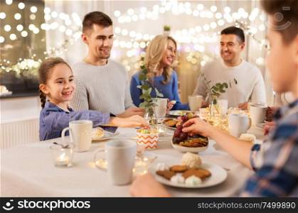 celebration, holidays and people concept - happy family having tea party at home. happy family having tea party at home