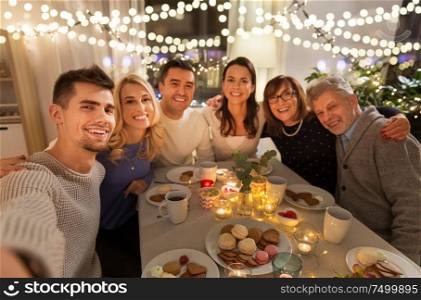celebration, holidays and people concept - happy family having tea party at home and taking selfie. happy family taking selfie at tea party at home