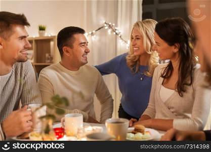 celebration, holidays and people concept - happy family or friends having tea party at home. happy family or friends having tea party at home