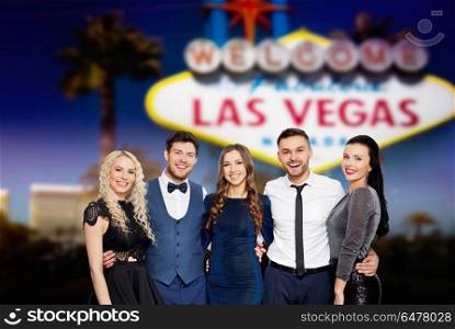 celebration, holidays and people concept - happy friends in party clothes hugging over festive lights background over welcome to fabulous las vegas sign background. happy friends in party clothes in las vegas. happy friends in party clothes in las vegas