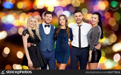 celebration, holidays and people concept - happy friends in party clothes hugging over festive lights background. happy friends at party hugging over festive lights. happy friends at party hugging over festive lights