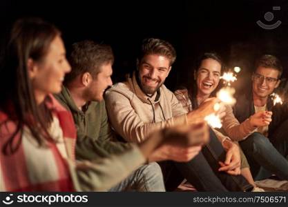celebration, holidays and people concept - happy friends with sparklers at night outdoors. happy friends with sparklers at night outdoors
