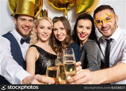 celebration, luxury and holidays concept - happy friends with golden party props clinking champagne glasses. happy friends clinking champagne glasses at party